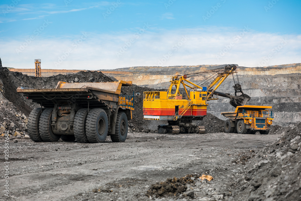 Large quarry dump truck. Loading the rock in dumper. Loading coal into body truck. Production useful minerals. Mining truck mining machinery, to transport coal from open-pit as the coal production. Large quarry dump truck. Loading the rock in dumper. Loading coal into body truck. Production useful minerals. Mining truck mining machinery, to transport coal from open-pit as the coal production.