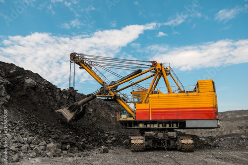 Large quarry dump truck. Loading the rock in dumper. Loading coal into body truck. Production useful minerals. Mining truck mining machinery, to transport coal from open-pit as the coal production.