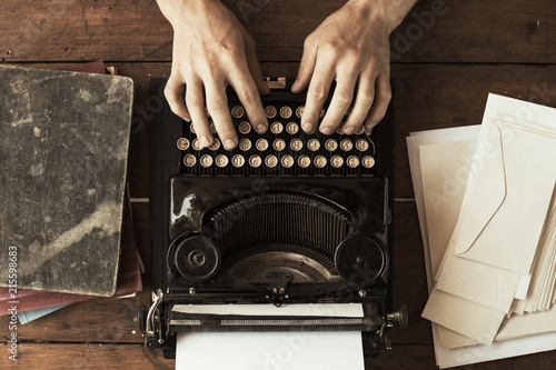 Young man's hands typing on an antique vintage typewriter