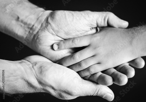black and white photo of a father holding his son's hand