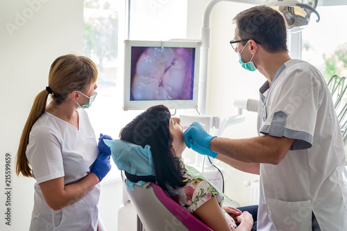 Doctor examining patient's teeth with intraoral camera