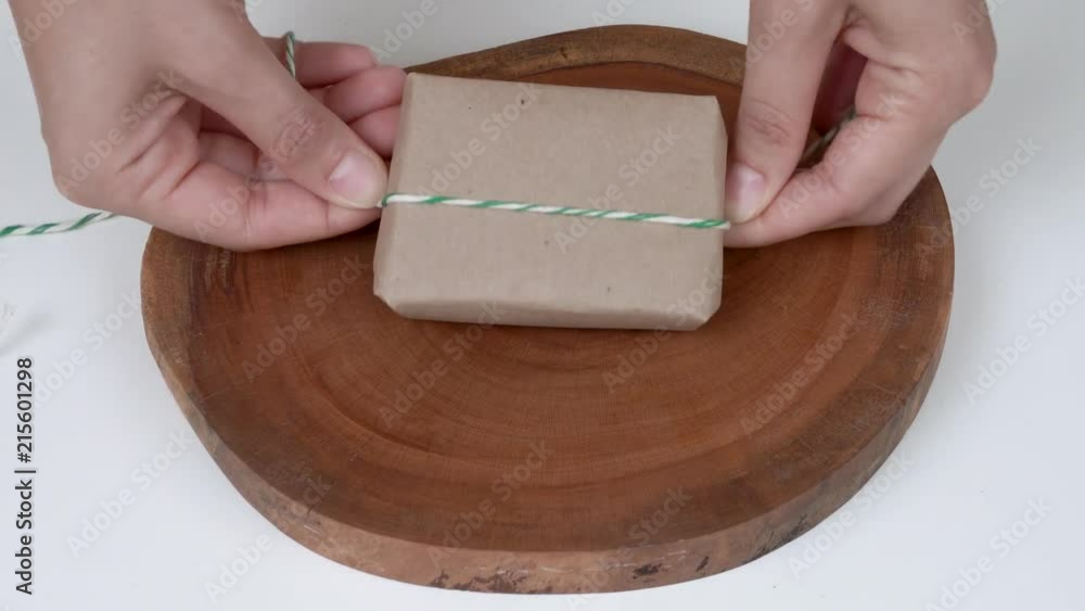 A close-up of a bar of natural soap wrapped in natural brown paper