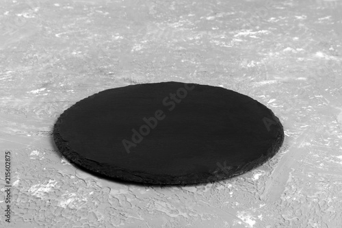 Black slate round stone on cement background. perspective view