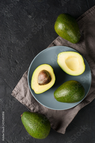 Some fruit of avocado whole and half on plate