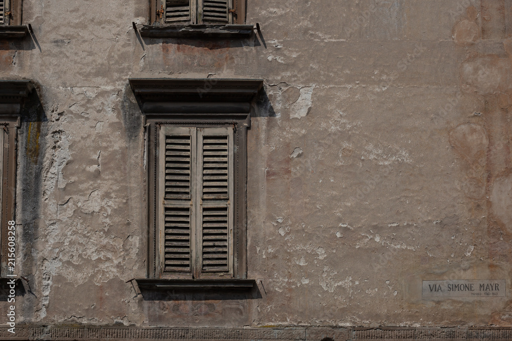 Beautiful texturd wall, window shutter and street sign in Bergamo, Italy