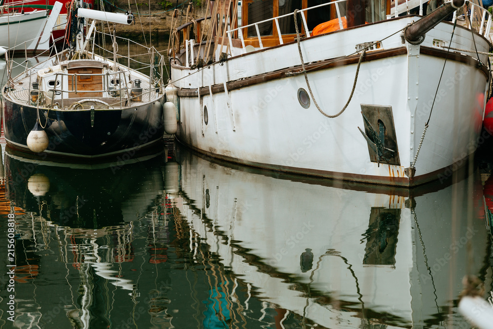 Luxury yachts moored in marina. Boats reflected in the water of Honfleur harbor, Upper Normandy, France. Close up. Yachting, vacation, luxury lifestyle and wealth concept