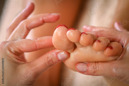 Massage therapist massaging legs of pregnant woman