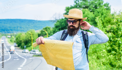 Pick up local map. Tourist backpacker looks at map choosing travel destination at road. Around the world. Find map large sheet of paper. Allow recognize enough details to walk somewhere if get lost
