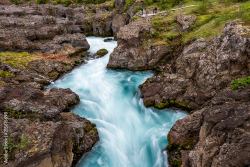 Long exposure smooth colorful blue aqua turquoise water waterfall cascade aerial view down of Hraunfossar Lava Falls in Iceland, landscape view © Kristina Blokhin