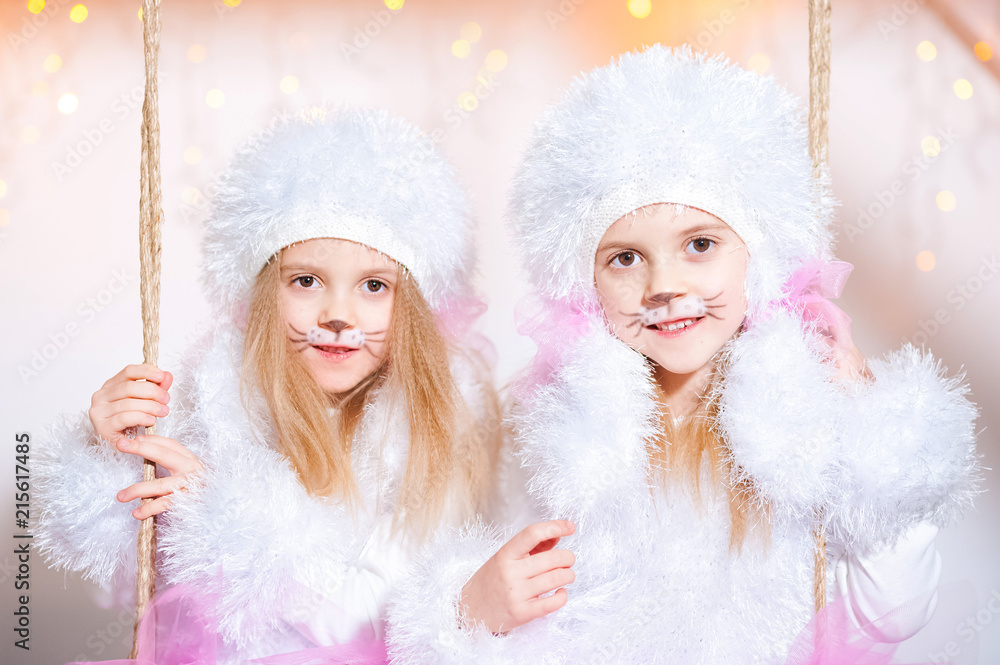 Two sisters twins in the costumes of dog poodles for the New Year. Makeup is like a dog. Portrait of a beautiful girl close-up on a background of Christmas lights Two sisters twins in the costumes of dog poodles for the New Year. Makeup is like a dog. Portrait of a beautiful girl close-up on a background of Christmas lights