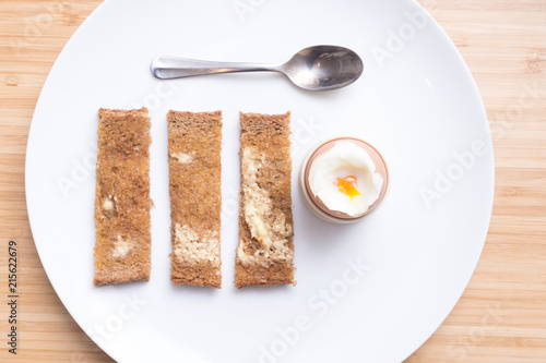Soft boiled eggs with toast on a white plate. Breakfast