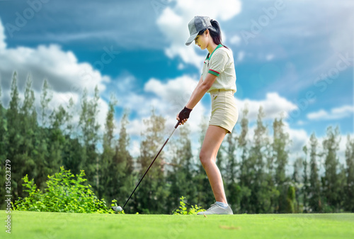 Young woman golfer stay on the green being hit the golf ball away to the fairway competitive of young woman in golf course