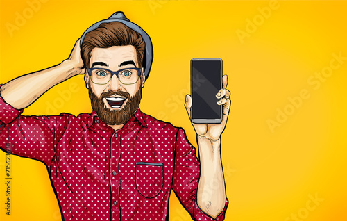Attractive smiling hipster in specs with phone in the hand in comic style. Pop art man in hat holding smartphone. Digital advertisement male model showing the message or new app on cellphone. 