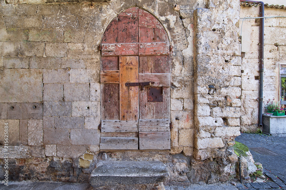 Ancient wooden door with a stone porch