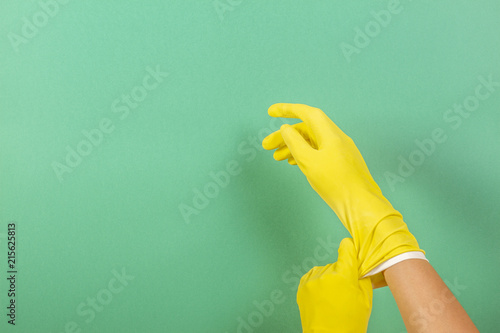 Hands putting on yellow rubber gloves