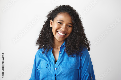Canvas Print Picture of gorgeous African student girl wearing casual blue shirt rejoicing at good results on exams, smiling broadly