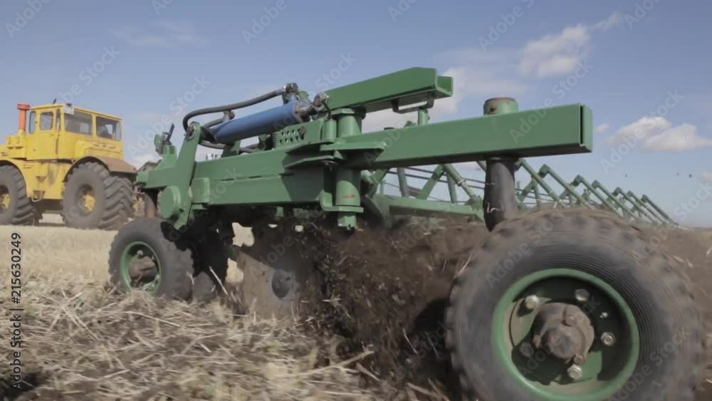 the tractor harrows the ground the tractor harrows the ground