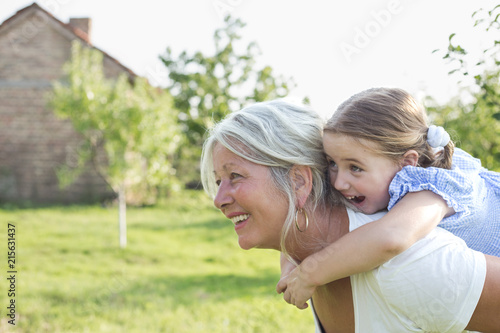 Little girl on a piggy back ride with her grandmother