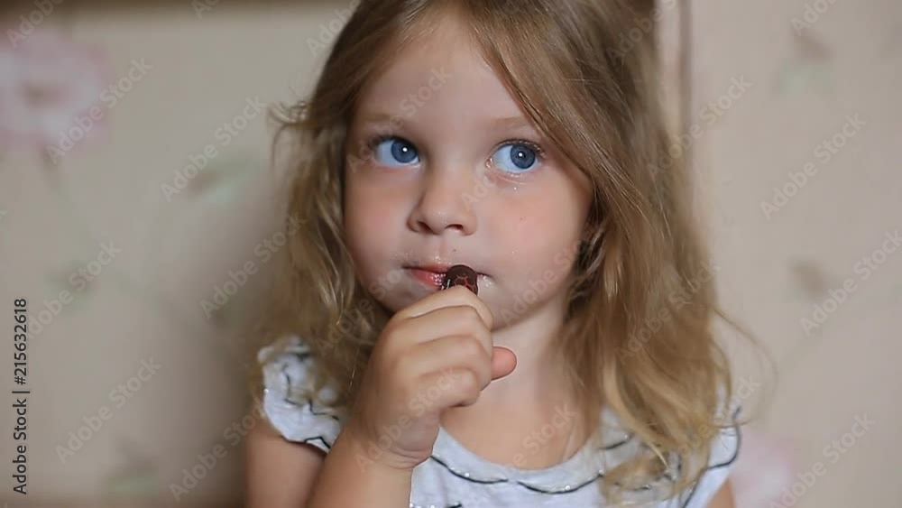 a little two-year-old girl paints her lips with her mother's lipstick. a little two-year-old girl paints her lips with her mother's lipstick.