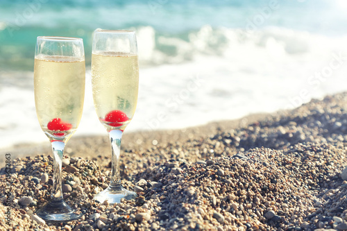 Two glasses of cold white champagne  on  the beach, luxury resort with sea view. Romantic vacation