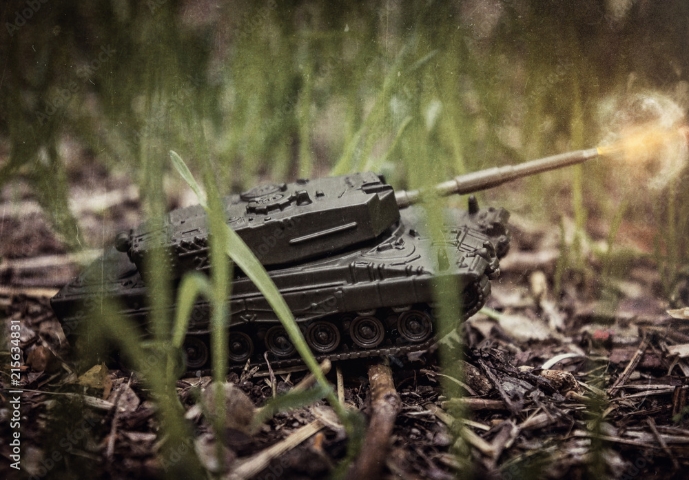 Toy tank on nature background with ground and green grass Toy tank on nature background with ground and green grass