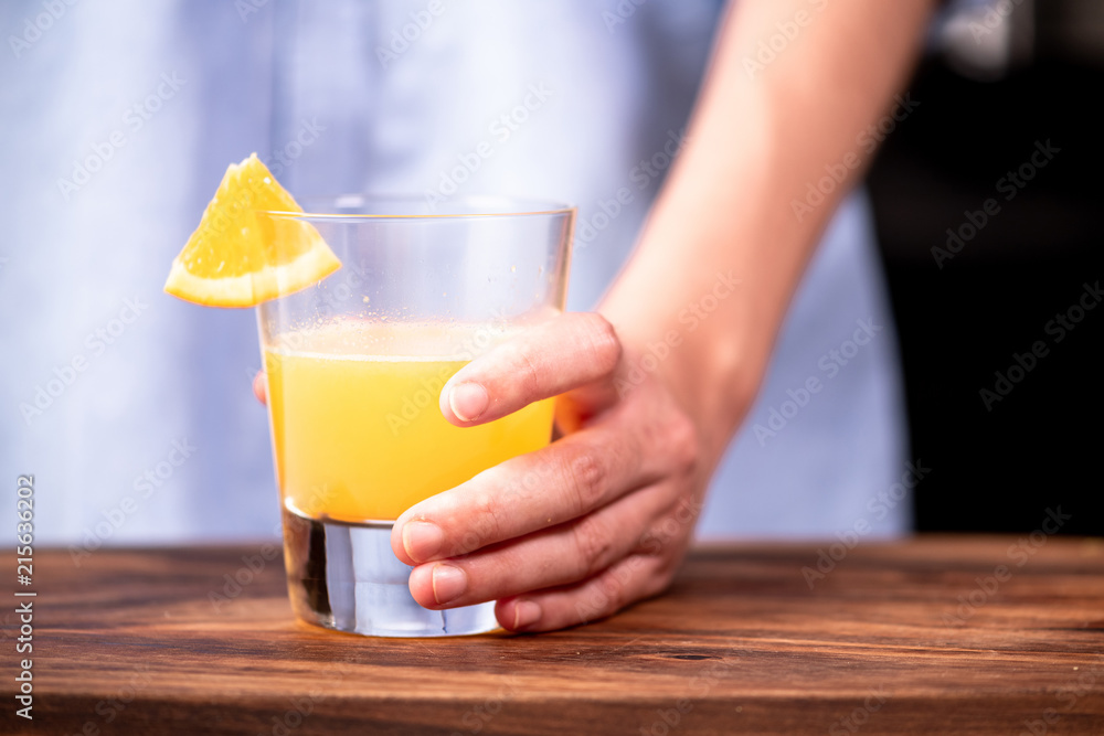 Woman holding a fresh orange juice in a glass. Woman holding a fresh orange juice in a glass.