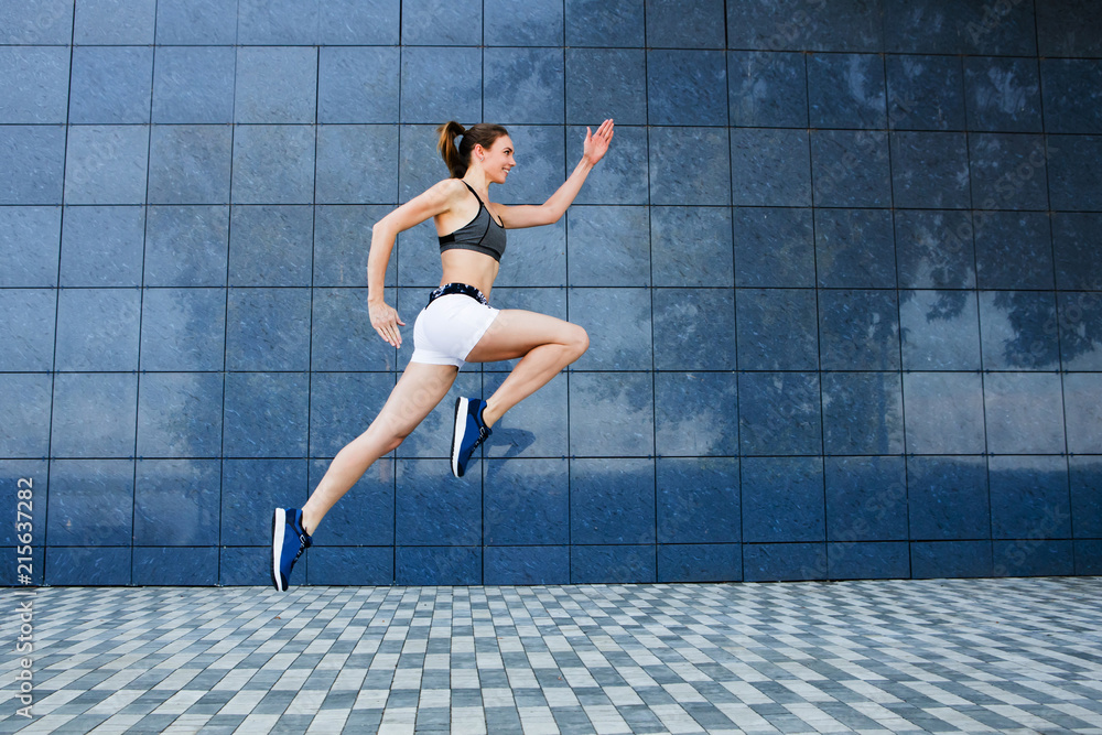 Young woman in sportswear  jumping and running outdoors, urban style.