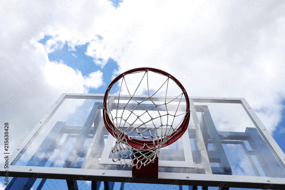 Basketball Hoop on a street basketball court on the background of blue sky in the clouds Basketball Hoop on a street basketball court on the background of blue sky in the clouds