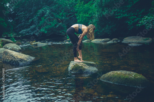 Young woman standing on rock in the river