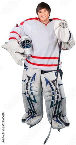 Male ice hockey player in helmet holding hockey stick on a white