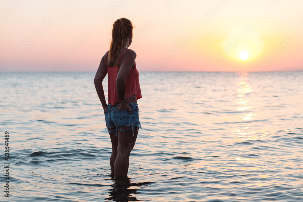 Young woman enjoying sea and sunset