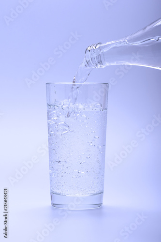 Mineral fresh water pouring into glass from bottle