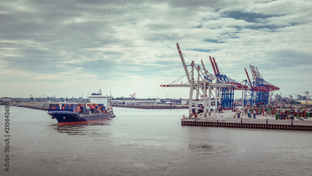 Luftaufnahme eines Container-Terminals im Hafen von Hamburg mit einem kleinen Containerschiff