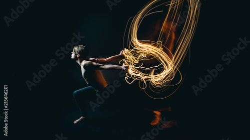 metaphor purposeful beautiful naked young man resistance to battle with problems and depression. Drawing with light. Long exposure creative emotional portrait. Dark background. photo