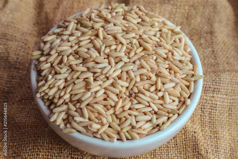 Raw brown rice in a bowl. top view food background Raw brown rice in a bowl. top view food background