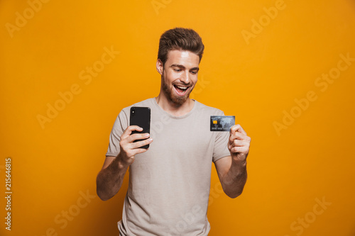 Portrait of an excited young man holding mobile phone