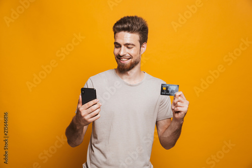 Portrait of a satisfied young man using mobile phone