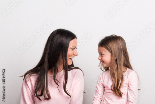 A small girl and her mother looking at each other in a studio.