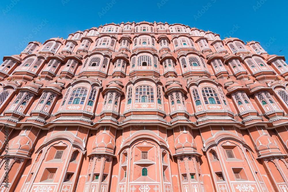 View of Hawa Mahal (Palace of Winds or Palace of the Breeze) with blue sky in background. It's constructed of red and pink sandstone, located on the edge of City Palace, Jaipur, Rajasthan, India View of Hawa Mahal (Palace of Winds or Palace of the Breeze) with blue sky in background. It's constructed of red and pink sandstone, located on the edge of City Palace, Jaipur, Rajasthan, India