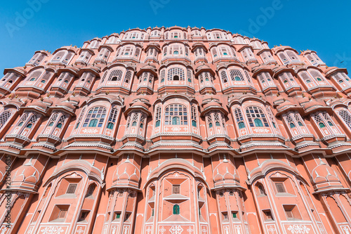 View of Hawa Mahal (Palace of Winds or Palace of the Breeze) with blue sky in background. It's constructed of red and pink sandstone, located on the edge of City Palace, Jaipur, Rajasthan, India