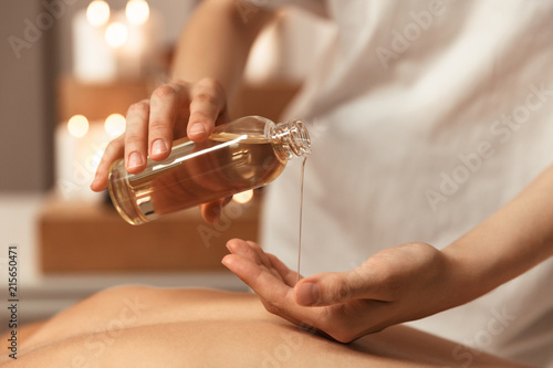 Canvas Close up of a woman masseur pouring massage oil