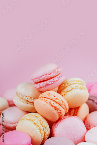 Sweet macaroons with vintage pastel colored tone on pink background.