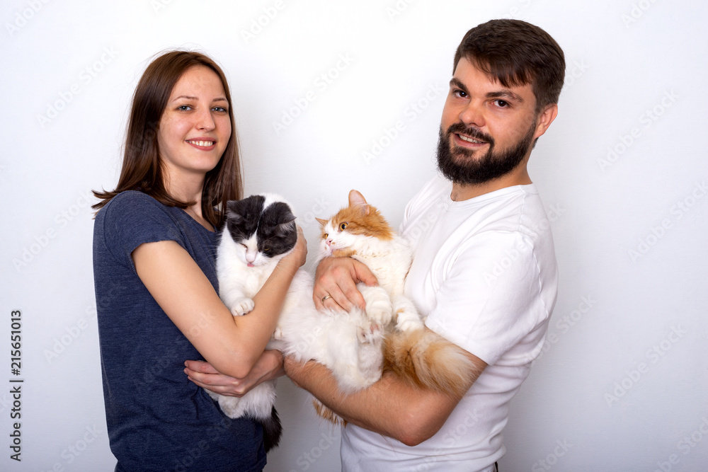 Happy young couple with their well-groomed cats