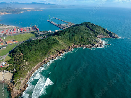  Aerial view of Brazilian beach with white sand, blue sea, and harbor.