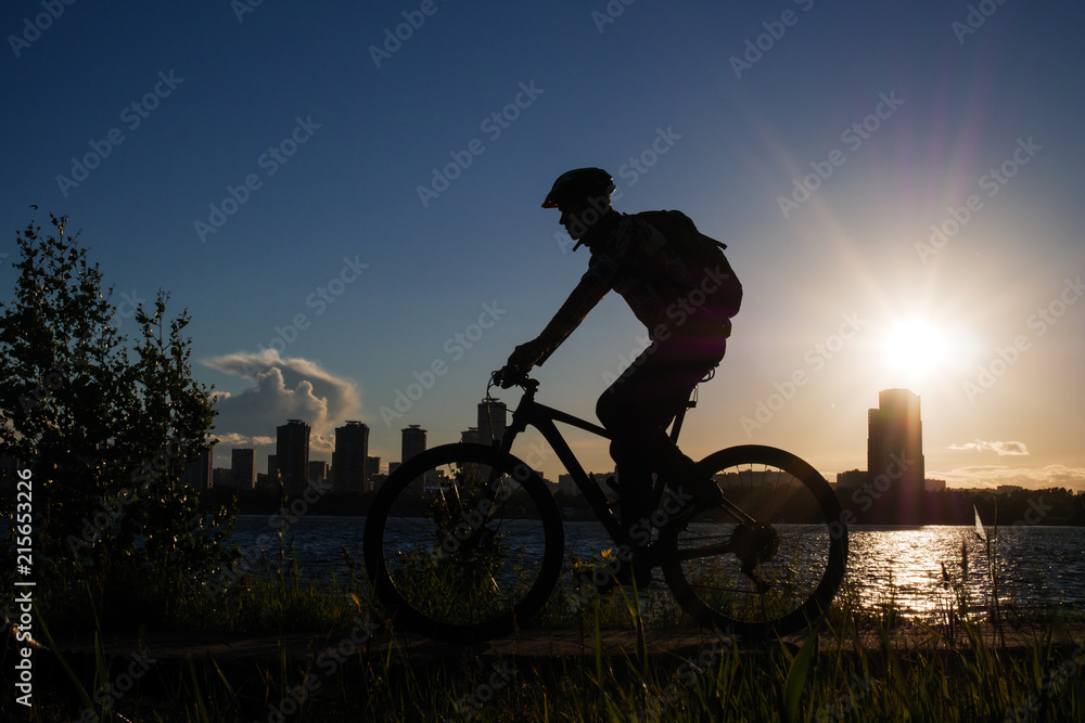 Obraz premium Photo of bicyclist wearing helmet riding around city in evening