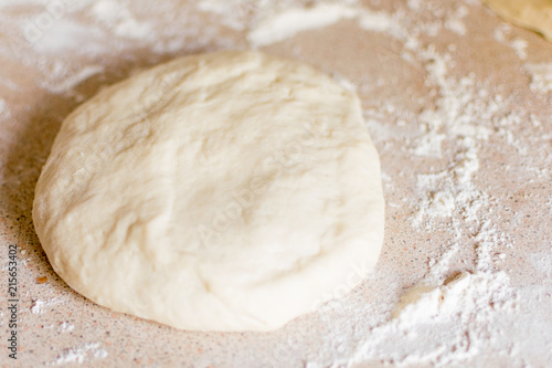 Yeast dough for pizza on the table.