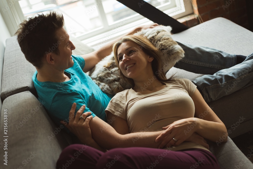 Smiling couple relaxing on sofa at home Smiling couple relaxing on sofa at home