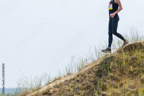 Runner going down from steep descent in trail running competition