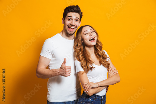 Фотография Portrait of cheerful people man and woman in basic clothing smiling and showing