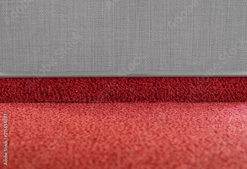Carpet floor with a carpet baseboard on a grey wall. photo